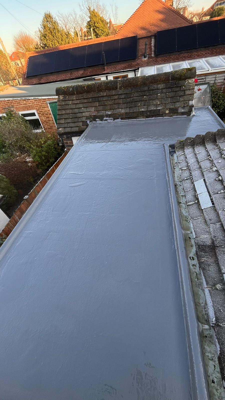 New GRP fibreglass flat roof next to pitched tiles — clean finish